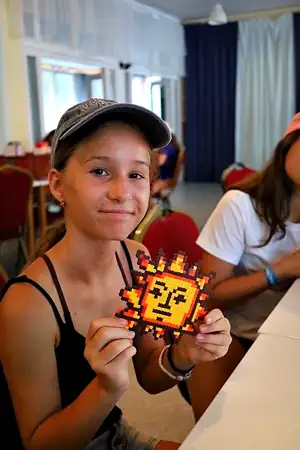 dievča so slniečkom zo zažehľovacích korálok v letnom tábore Fantázia
