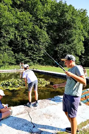 chlapci s udicou pri jazierku v letnom tábore Fantázia